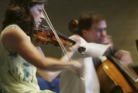 Members of the Miami String Quartet (left to right) Cathy Meng Robinson and Keith Robinson play Wednesday, July 16, 2003, at the First Presbyterian Church in DeBary. (Photo: Chad Pilster)
